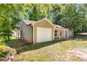 This cozy home features an attached one-car garage and a manicured yard, nestled among mature trees at 106 Blackfoot Dr, Louisburg, NC 27549