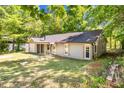 The backyard of this inviting home features a peaceful green lawn and complemented by natural wooden accents at 106 Blackfoot Dr, Louisburg, NC 27549