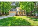 Charming two-story home with a well-manicured lawn, mature trees, and an attached two-car garage at 11 Bridgeport Dr, Durham, NC 27713