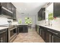 Modern kitchen with stainless steel appliances, dark cabinets, white countertops, and subway tile backsplash at 1101 Washhouse Ln, Wake Forest, NC 27587