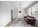 Bright living room showcasing a brown leather couch, patterned rug, and natural light at 1101 Washhouse Ln, Wake Forest, NC 27587