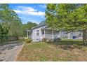 Charming home featuring gray siding, white trim, inviting front porch, and partially shaded yard at 1112 Mark St, Raleigh, NC 27601