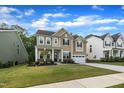 Charming two-story home with a well-manicured lawn, covered porch and attached two car garage at 112 Serenata Dr, Holly Springs, NC 27540