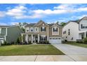 Charming two-story home with a well-manicured lawn, covered porch and attached two car garage at 112 Serenata Dr, Holly Springs, NC 27540