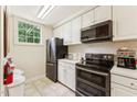 Cozy kitchen with white cabinets, black appliances, and a window providing natural light at 11475 Club Dr, Chapel Hill, NC 27517