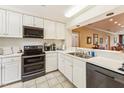 Bright kitchen featuring white cabinets, black appliances, and an open layout to the living area at 11475 Club Dr, Chapel Hill, NC 27517
