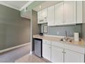Compact kitchenette with white cabinets, sink, and small refrigerator, ideal for convenience at 11483 Club Dr, Chapel Hill, NC 27517