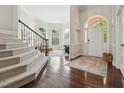 Inviting foyer with hardwood floors, staircase, and large windows creating a bright, open entrance to the home at 11916 Deneb Ct, Raleigh, NC 27614