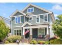 Charming two-story home with a covered front porch, stone accents, and an American flag at 12 Beacon Ridge Blvd, Chapel Hill, NC 27516