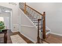Elegant staircase with dark wood and iron railing, complemented by neutral walls at 12404 Huntley Chase Dr, Durham, NC 27703