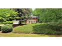 Traditional brick home with a well-kept lawn and mature trees providing shade and privacy at 1274 Candlewood Dr, Elon, NC 27244