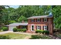 Charming brick home with an attached garage and well-maintained landscaping and a classic front door at 1274 Candlewood Dr, Elon, NC 27244