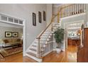 Grand foyer with hardwood floors, decorative staircase, and views into the living spaces at 1312 Glenden Falls Way, Raleigh, NC 27614