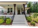 Inviting front porch with rocking chairs and an entrance door with decorative wreath at 1344 Legend Oaks Drive Dr, Chapel Hill, NC 27517