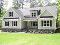 Inviting home features an attractive lawn, and stone accents, and metal awnings over the windows at 1430 Clifton Pond Rd, Louisburg, NC 27549