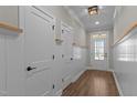 Well-lit hallway boasts board and batten trim, wood-look floors, and white doors with black hardware at 1430 Clifton Pond Rd, Louisburg, NC 27549