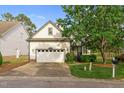 Charming home featuring a two-car garage, landscaped front yard, and mature trees at 17 Nicklaus Way, Clayton, NC 27520