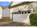 Attached two car garage door with decorative windows on a light yellow home at 17 Nicklaus Way, Clayton, NC 27520