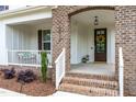 Inviting front porch with brick accents, a decorative wreath, and space for seating, creating a warm welcome at 2014 Anna Lilley Dr, Fuquay Varina, NC 27526