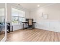 Well-lit home office with neutral walls, wainscotting, wood flooring, and a large window for natural light at 2014 Anna Lilley Dr, Fuquay Varina, NC 27526