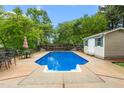 Inviting in-ground pool with a spacious concrete deck and surrounding lush greenery at 204 Random Ln, Burlington, NC 27215