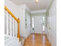 Inviting foyer features hardwood floors, staircase with wood railing, and light green walls at 216 Ruby Walk Dr, Morrisville, NC 27560