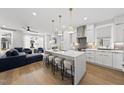 Open concept kitchen featuring a large island with seating and stylish pendant lighting at 221 Woodsborough Pl, Raleigh, NC 27601