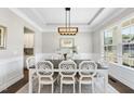 Elegant dining room with stylish lighting, wainscoting, and ample natural light from the window at 2527 Sidewinder Ct, Apex, NC 27523