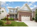Beautiful two-story home featuring a mix of brick and siding, a two-car garage, and lush green landscaping at 2728 Cameron Pond Dr, Cary, NC 27519