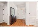 Bright foyer with hardwood floors, white trim, and a decorative mirror over a wooden console table at 2728 Cameron Pond Dr, Cary, NC 27519