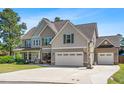 Traditional two-story home with a two car garage, a basketball hoop, and well-maintained landscaping at 311 Ocean Dr, Clayton, NC 27520