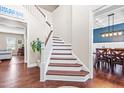 Bright foyer with hardwood floors and stairs leading to the second floor and views into other rooms at 311 Ocean Dr, Clayton, NC 27520