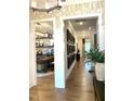 Hallway with wood floors that leads to an office space filled with decor and natural light at 3521 Olive Glen Dr, Apex, NC 27502