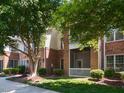 Brick condo building exterior with green space and mature shade trees creating an inviting atmosphere at 412 Waterford Lake Dr, Cary, NC 27519