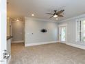Carpeted living room features a ceiling fan, recessed lighting, and access to a private outdoor space at 412 Waterford Lake Dr, Cary, NC 27519