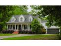 Charming two-story home with a welcoming front porch, manicured lawn, and an attached garage at 42 Miry Branch Ct, Garner, NC 27529