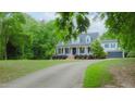 A long driveway leads to this charming white house with three dormers, a wide porch, and an attached two-car garage at 42 Miry Branch Ct, Garner, NC 27529