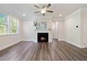 Bright living room featuring a fireplace, wood floors, and large windows that bring in lots of light at 425 Shadow Falls Dr, Wendell, NC 27591