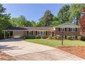 Charming brick home with a well-manicured lawn and a convenient carport, surrounded by lush greenery at 4300 Edgehill Ct, Raleigh, NC 27612