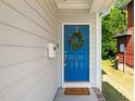 Close-up of a charming blue front door adorned with a wreath and a 'Welcome' doormat at 512 Montague Ln, Raleigh, NC 27601