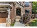 Inviting brick and stone front entrance with a covered porch and stone steps at 5600 Bennettwood Ct, Raleigh, NC 27612