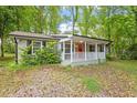 Inviting single-story home featuring a covered front porch, complemented by lush green surroundings at 5613 Deerborn Dr, Apex, NC 27539