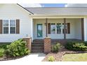 Inviting covered front porch with brick columns and an updated front door at 74 Pedernales Dr, Smithfield, NC 27577
