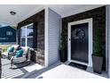 Inviting front porch with stylish seating area and decorative potted plants near the entrance at 7729 Calcutta Dr, Willow Springs, NC 27592