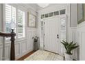 Bright foyer with elegant wainscoting, decorative mirror, and marble-potted plant at 8524 Society Pl, Raleigh, NC 27615