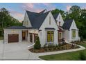 Elegant home showcasing multiple garage doors, a brick exterior, and manicured landscaping, offering both beauty and practicality at 9004 Meadow Pointe Ct, Wake Forest, NC 27587