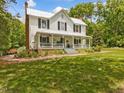 Beautiful two-story home with a metal roof, a large front porch, and a well-maintained lawn at 967 Bynum Rd, Pittsboro, NC 27312