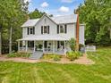 Quaint two-story home with a metal roof, a charming front porch, and a well-kept lawn at 967 Bynum Rd, Pittsboro, NC 27312