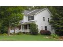 Beautiful home with a mix of siding and brick, a manicured lawn, and a charming front porch at 106 N Duelling Oaks Dr, Chapel Hill, NC 27517