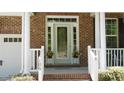 Close-up of the front porch, featuring decorative plants and a view of the entry door at 106 N Duelling Oaks Dr, Chapel Hill, NC 27517